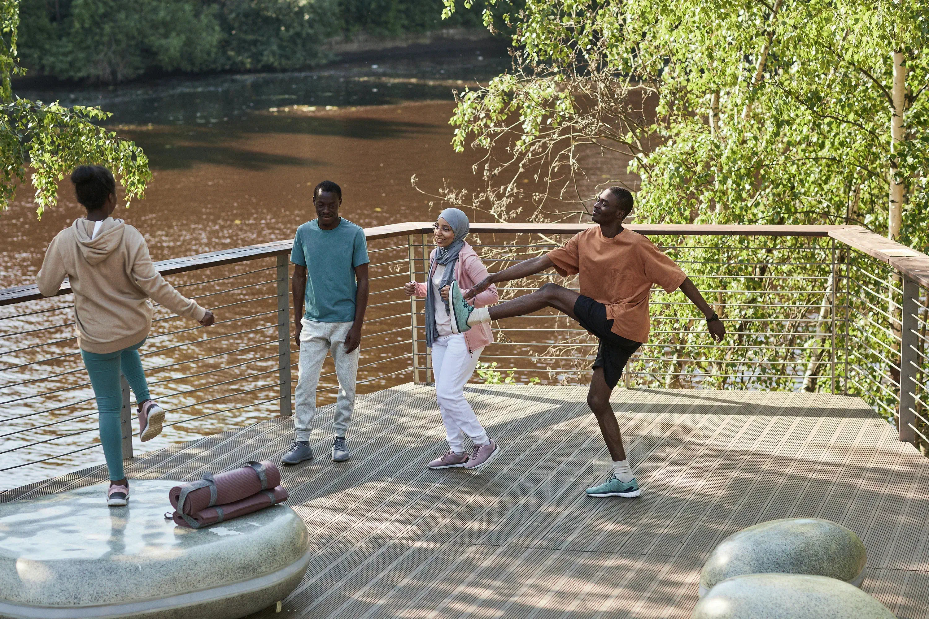 four people outside stretching